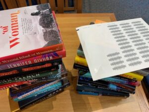 A stack of new books and a page of barcodes.